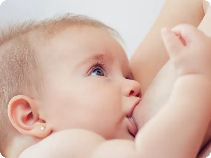 Un bebé mamando del pecho de su madre con un agarre correcto con la boca