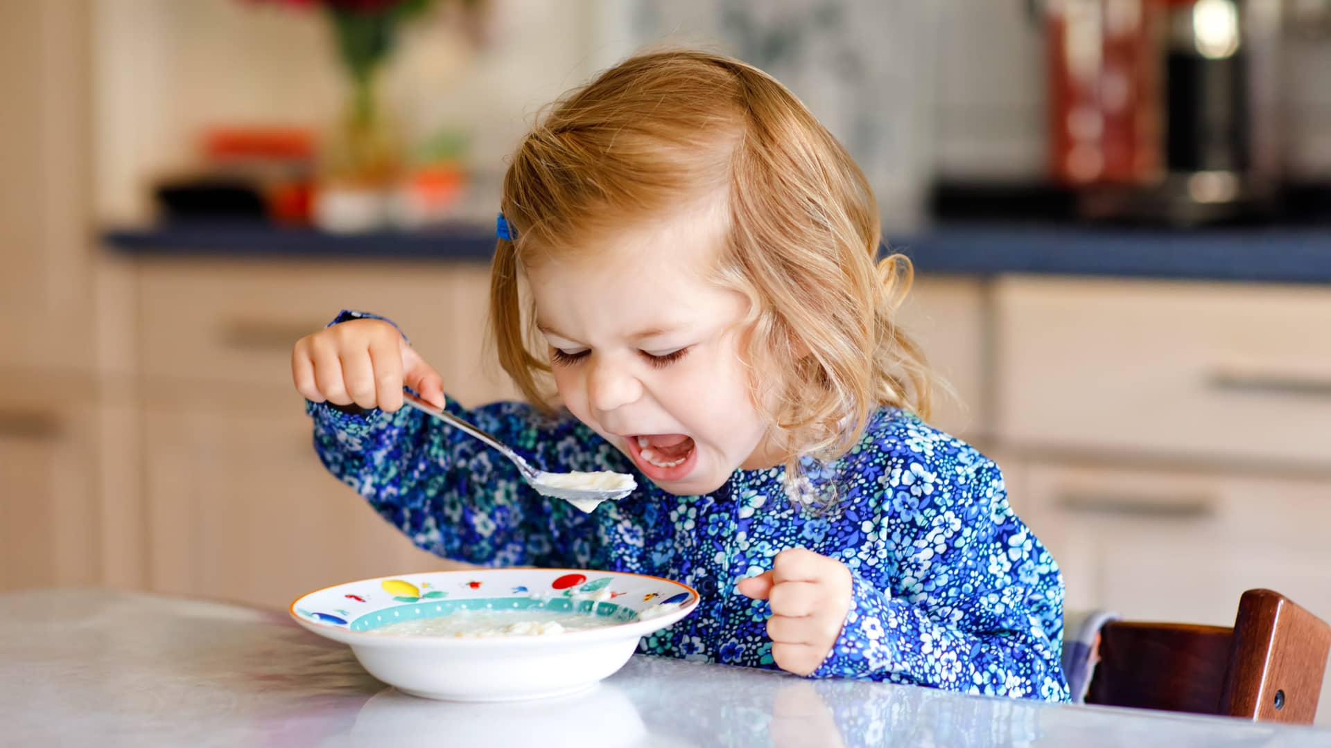 niña de un año tomando su tazon de avena en el desayuno