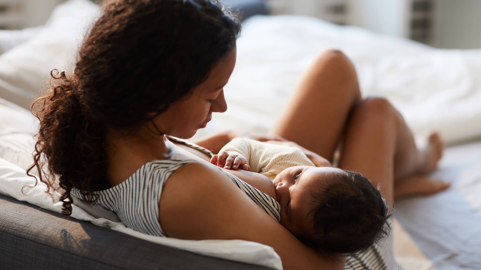 Chica amamantando a su bebé con la lactancia materna con unos componentes de leche que van cambiando con el tiempo