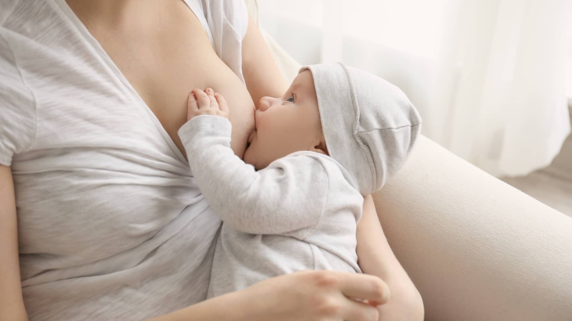 Mujer dando la lactancia materna a su bebé en el primer mes de vida