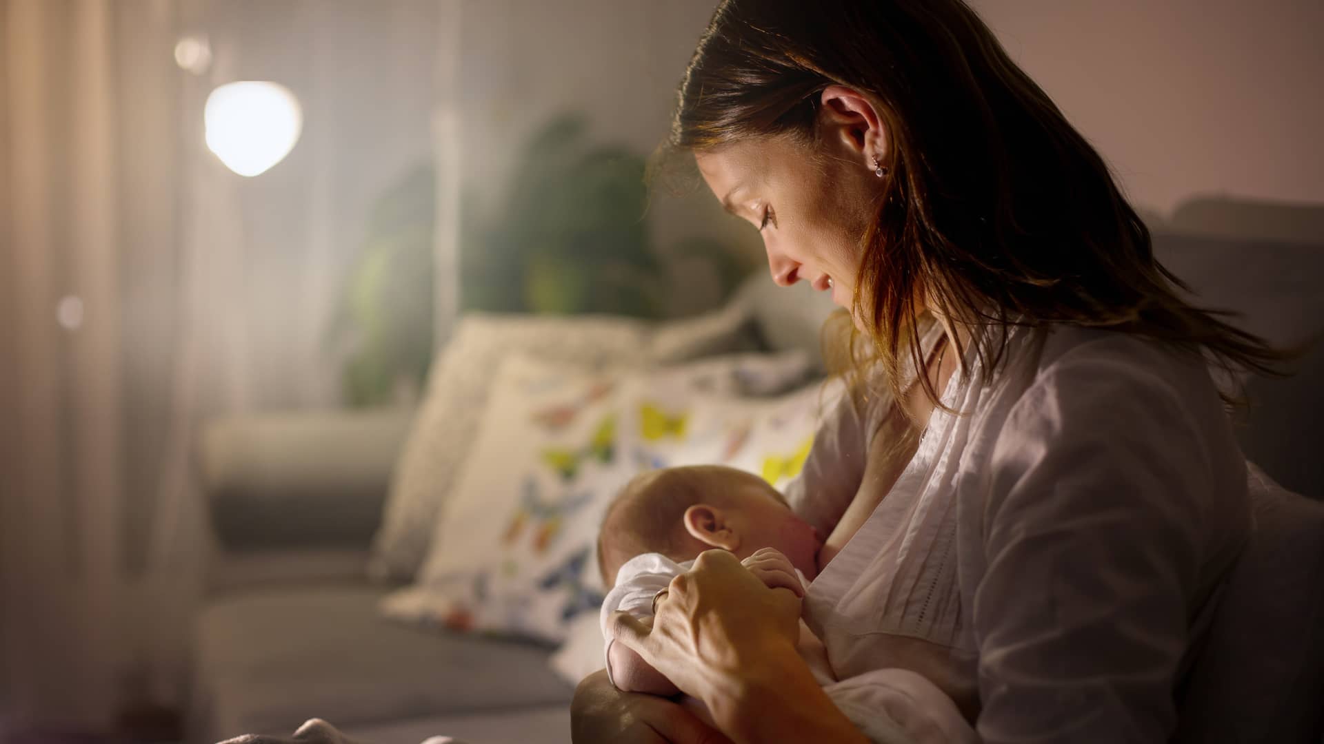 Chica amamantando a su bebé con la lactancia materna por la subida de leche