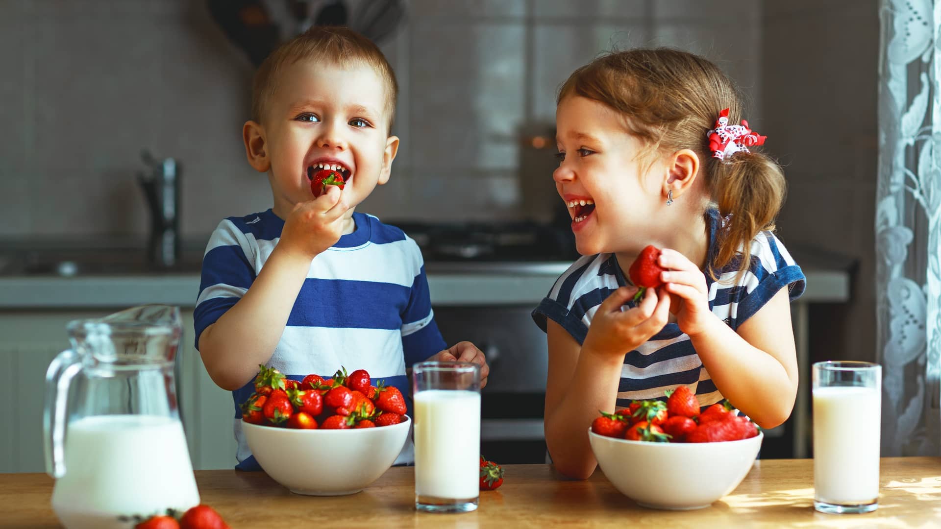 niños comiendo fresas porque tienen muchas vitaminas