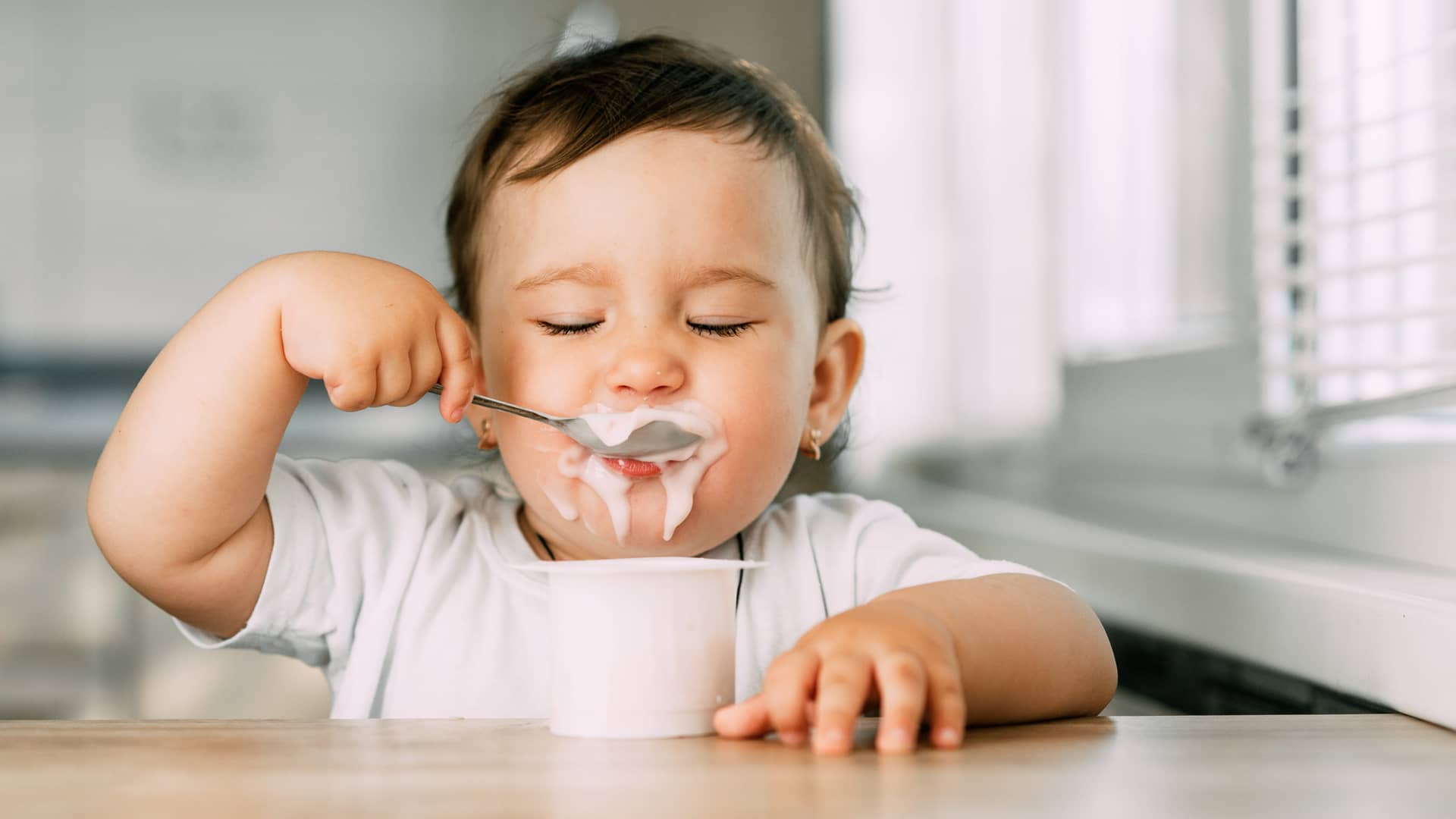 un bebe comiendo un yogur especifico para bebes un bebe comiendo un yogur especifico para bebes