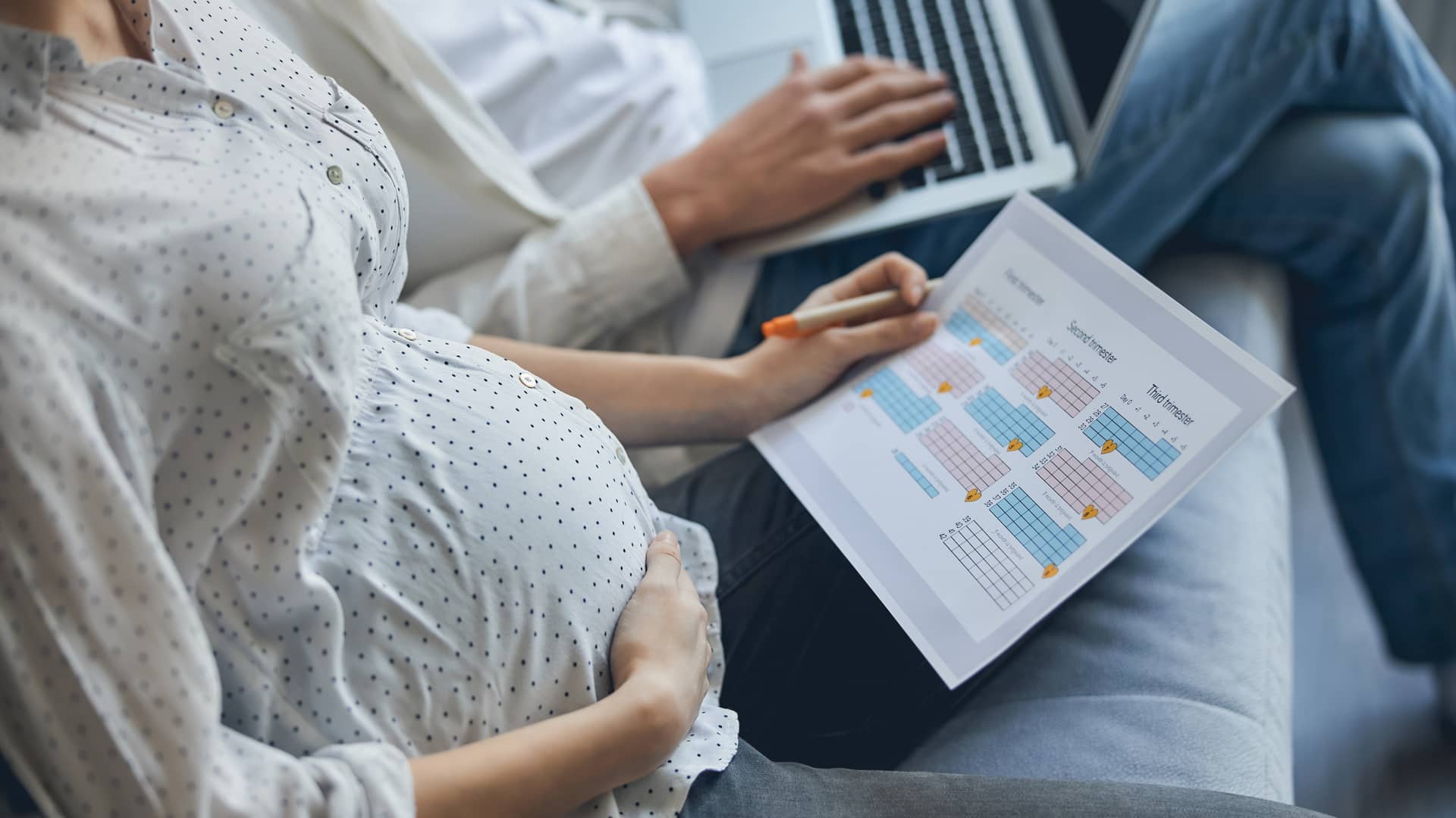 Mujer embarazada revisa un calendario de su embarazo tratando de calcular con la fecha de su última regla cuando podría dar a luz