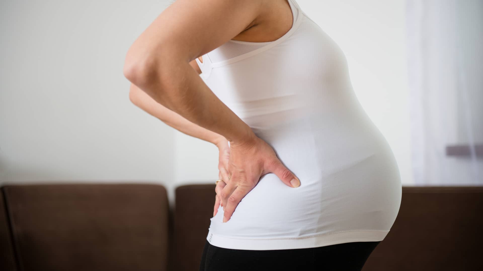 Tripa de una embarazada que se toca la zona lumbar por el dolor de ciática que le produce el embarazo