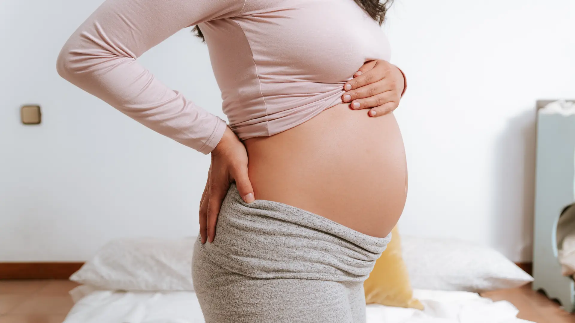 Una mujer posando con su barriga para representar el reposo relativo durante el embarazo
