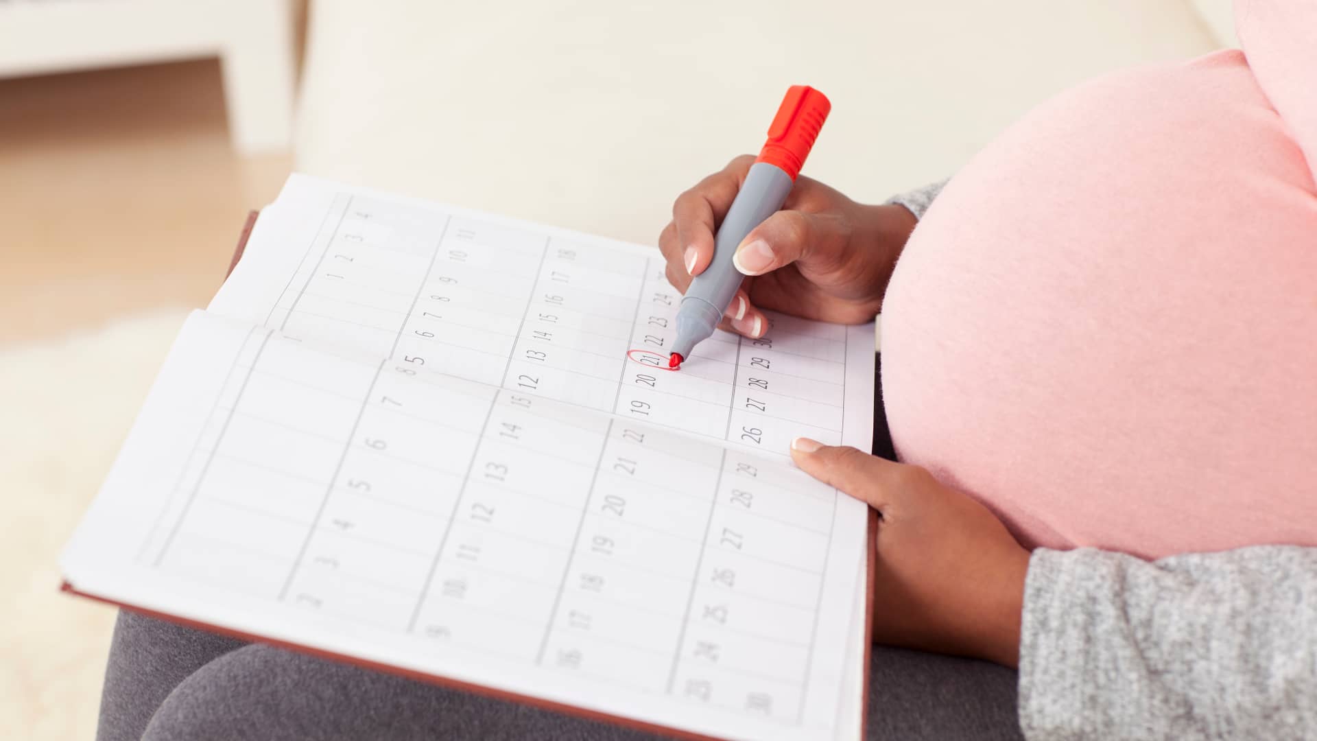 Mujer embarazada anotando en su calendario la fecha en la que saldrá de cuentas tras todas las semanas de embarazo
