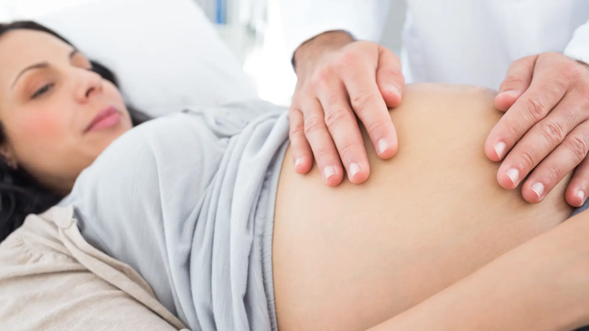 Una mujer embarazada en la consulta del medico a la que le van a practicar la versión cefálica externa