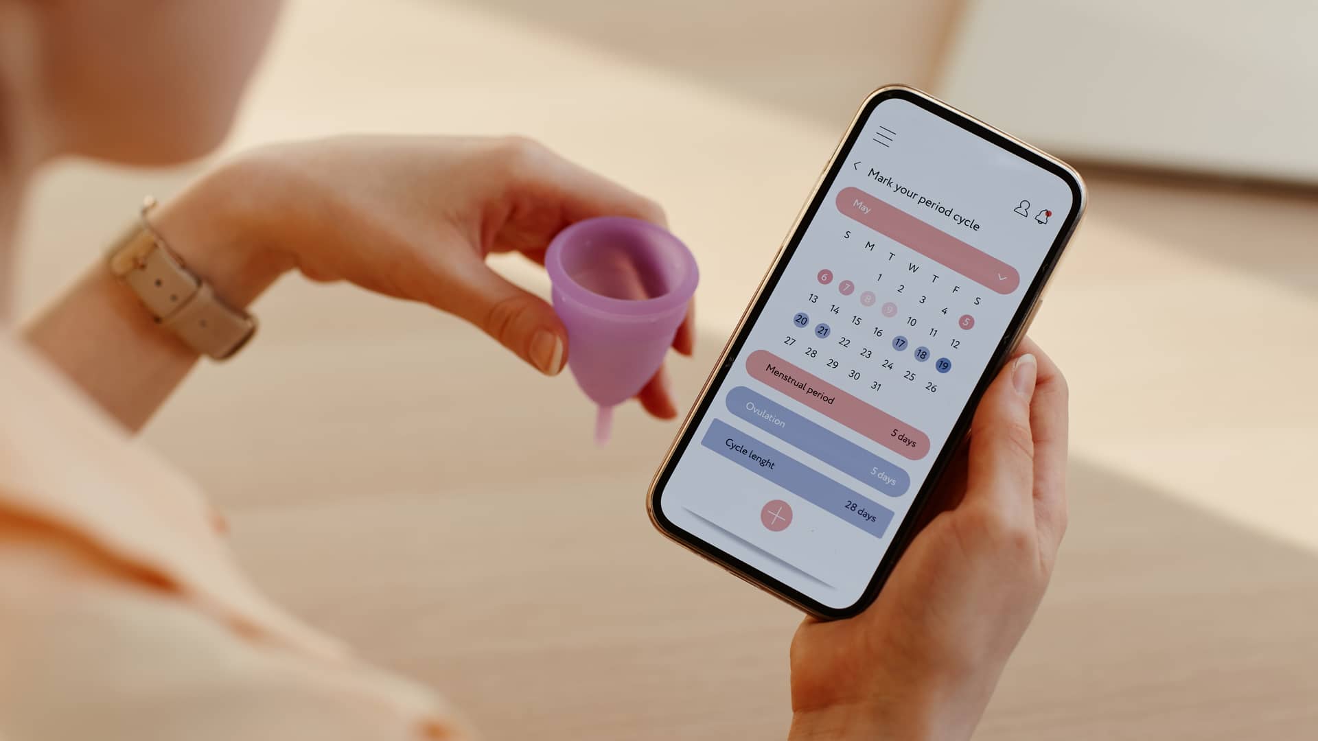 Una mujer consultando en su movil la app del periodo para estar al día con las fechas Una mujer consultando en su movil la app del periodo para estar al día con las fechas