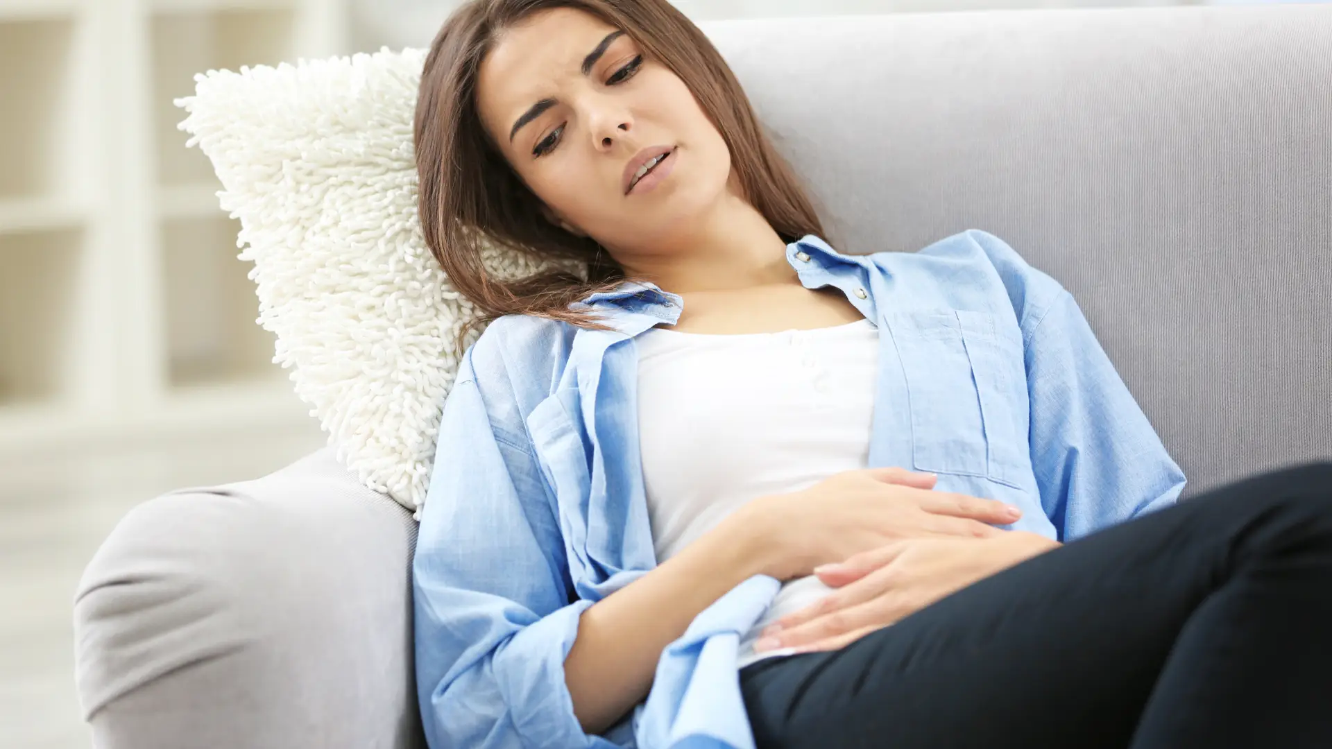 Mujer quejandose de un dolor en el abdomen bajo que no sabe si es por la regla o por un embarazo Mujer quejandose de un dolor en el abdomen bajo que no sabe si es por la regla o por un embarazo