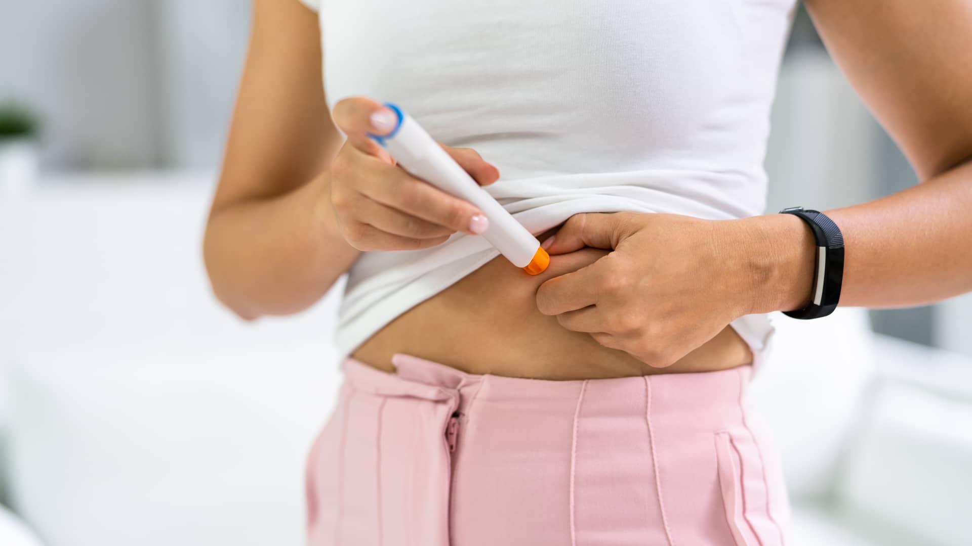 Una mujer inyectandose el medicamento Puregon en su tratamiento de estimulación ovárica Una mujer inyectandose el medicamento Puregon en su tratamiento de estimulación ovárica