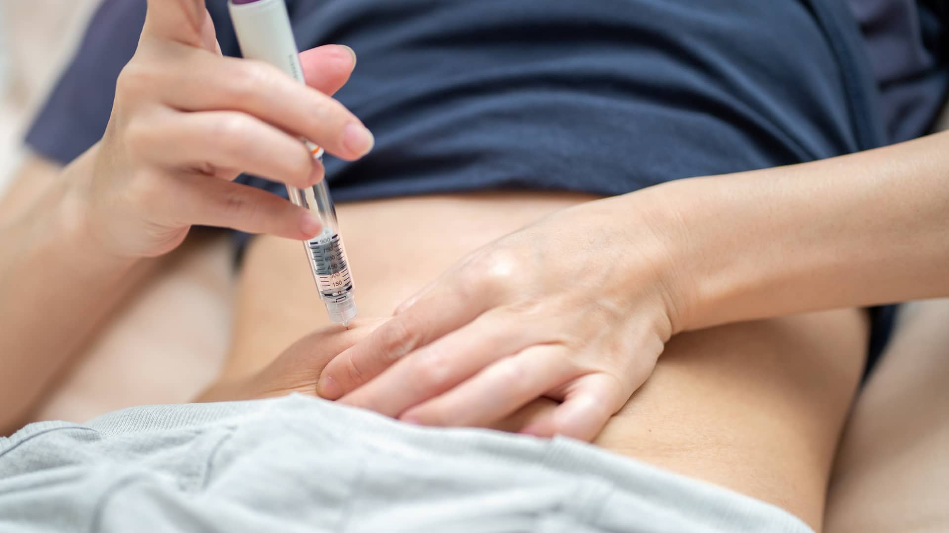 Una mujer poniéndose la inyección de la estimulación ovárica Una mujer poniéndose la inyección de la estimulación ovárica