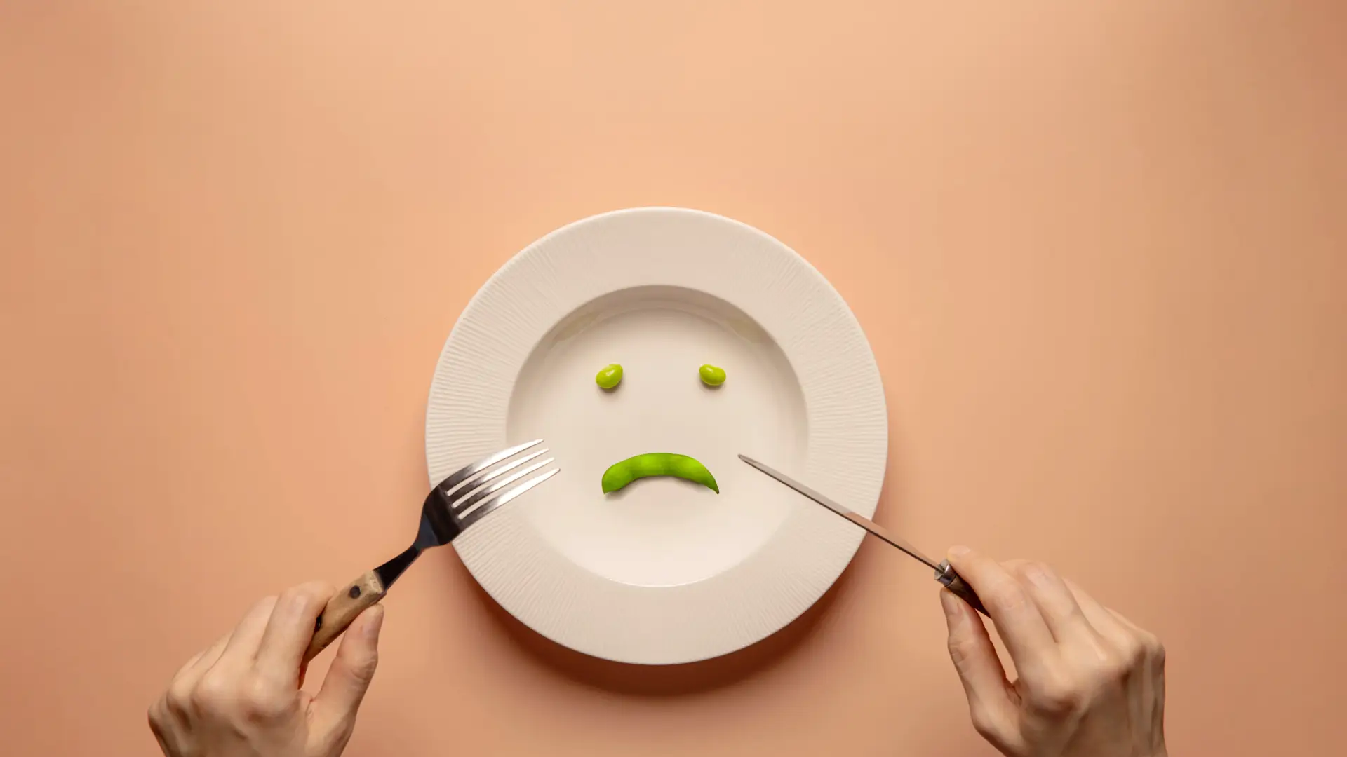 Plato con poca comida y cara triste para representar como los trastornos alimentarios producen infertilidad