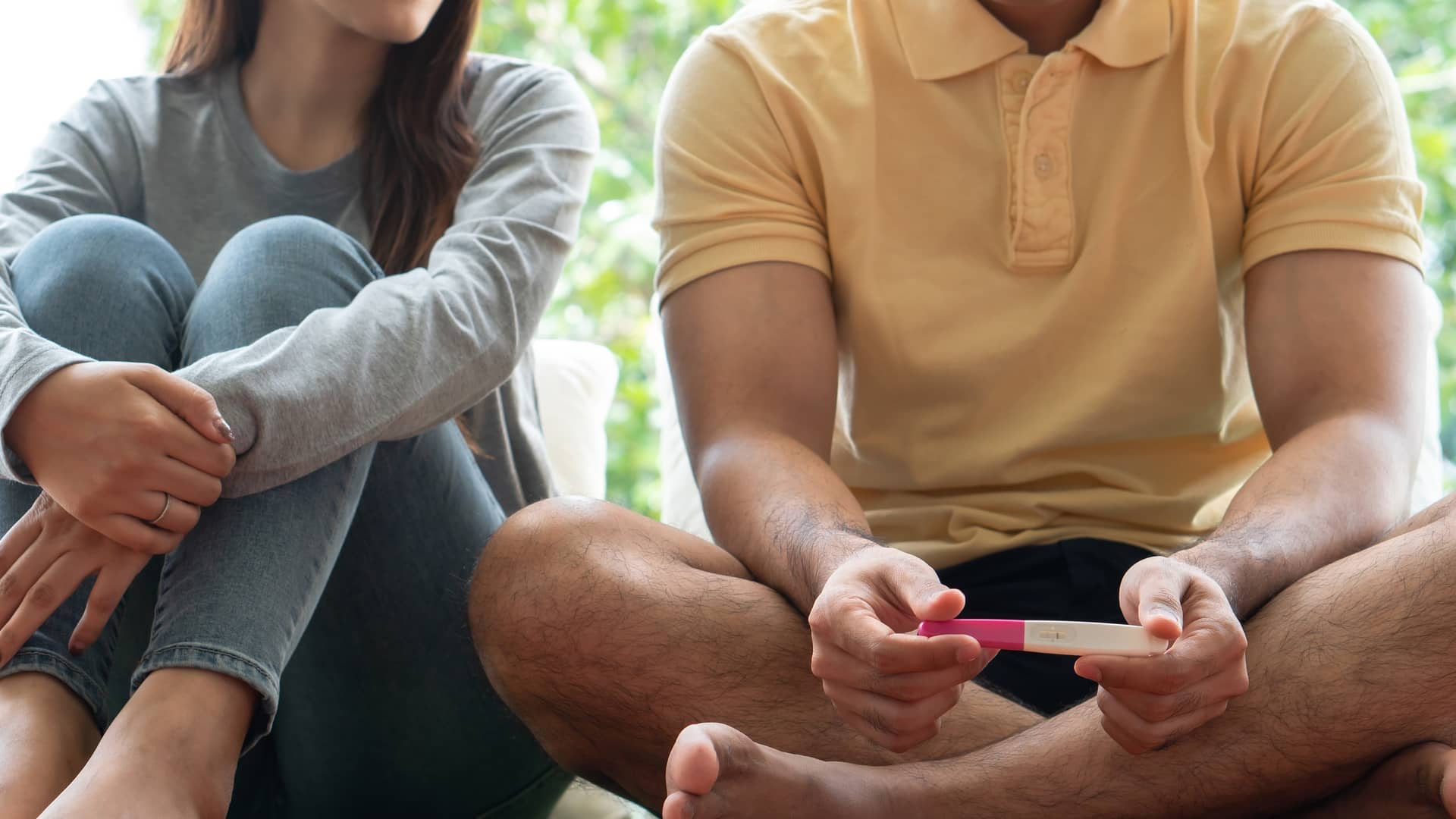 Un pareja con gesto triste mirando un test de embarazo negativo porque tiene problemas de infertilidad Un pareja con gesto triste mirando un test de embarazo negativo porque tiene problemas de infertilidad