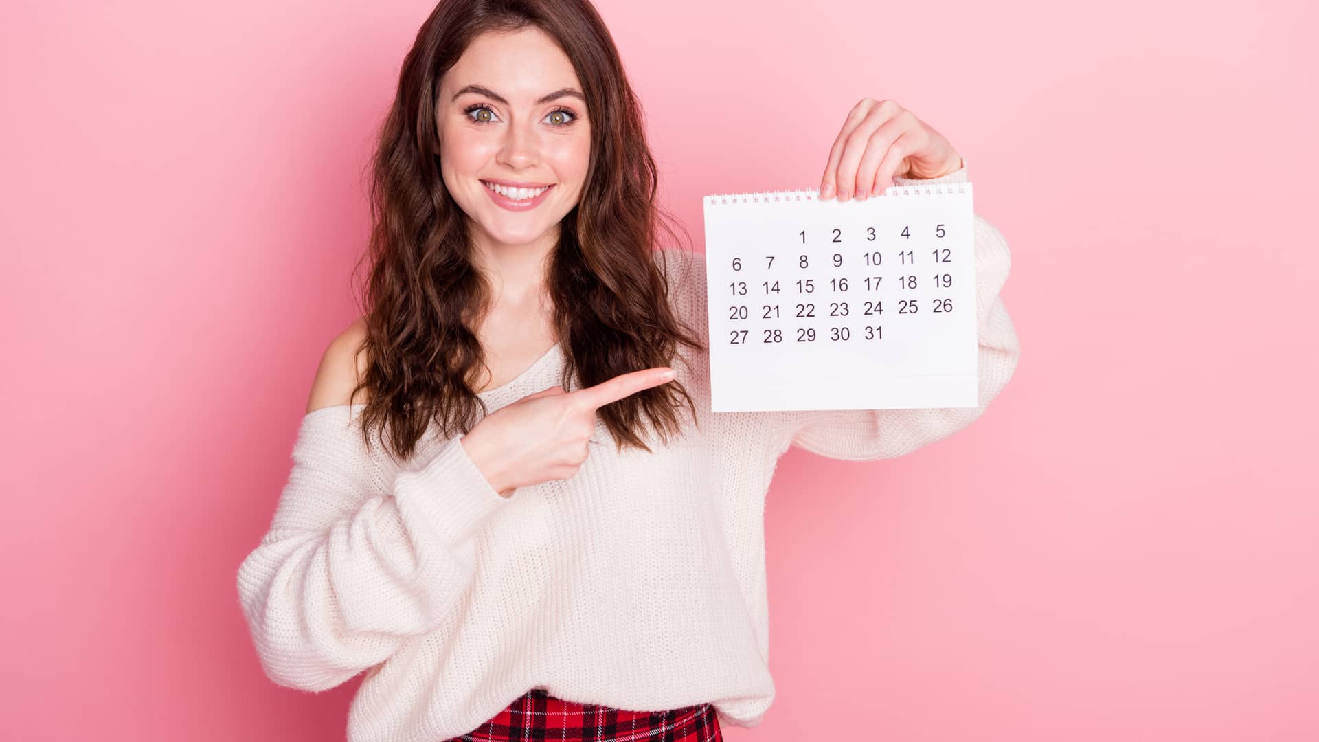 Una mujer sujetando un calendario para representar la betaespera de un proceso de inseminación aritificial