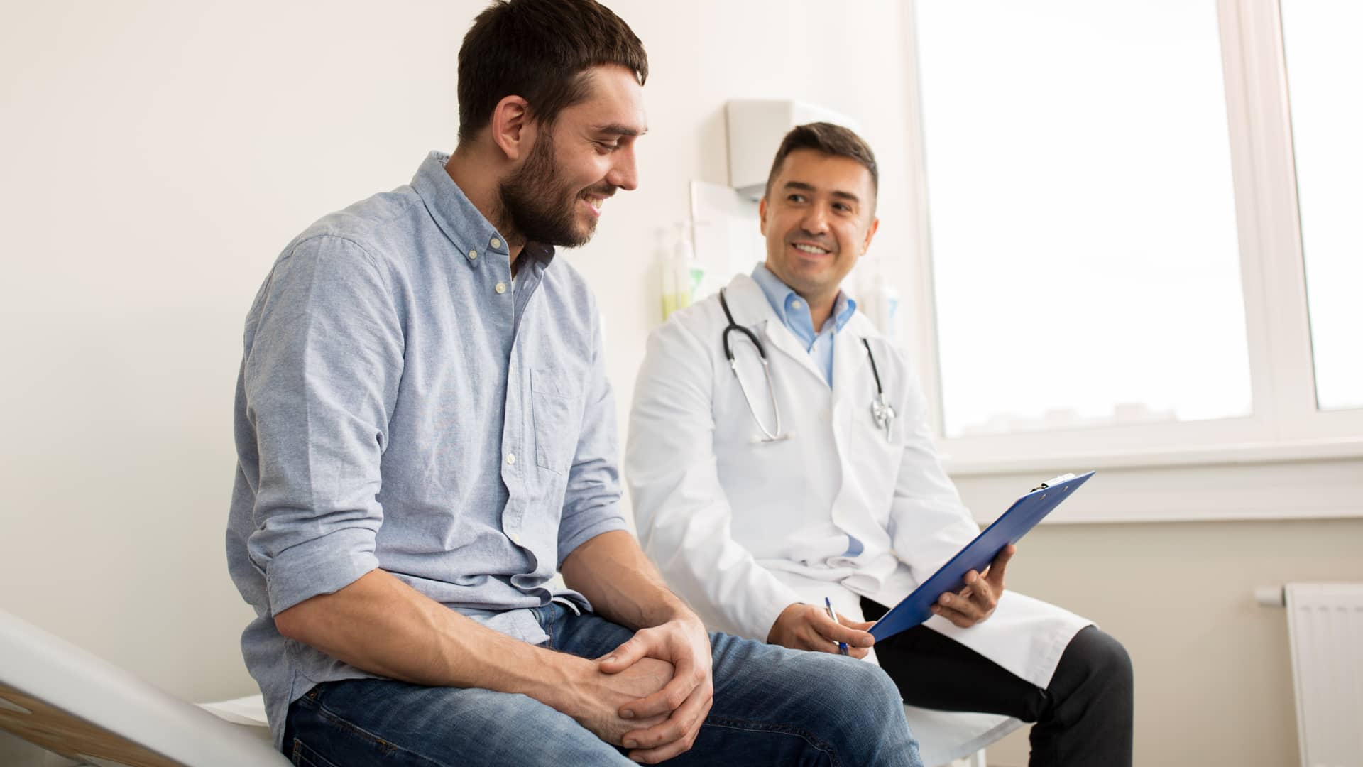 Hombre joven en el medico consultando sobre las pruebas de fettilidad en hombres Hombre joven en el medico consultando sobre las pruebas de fettilidad en hombres