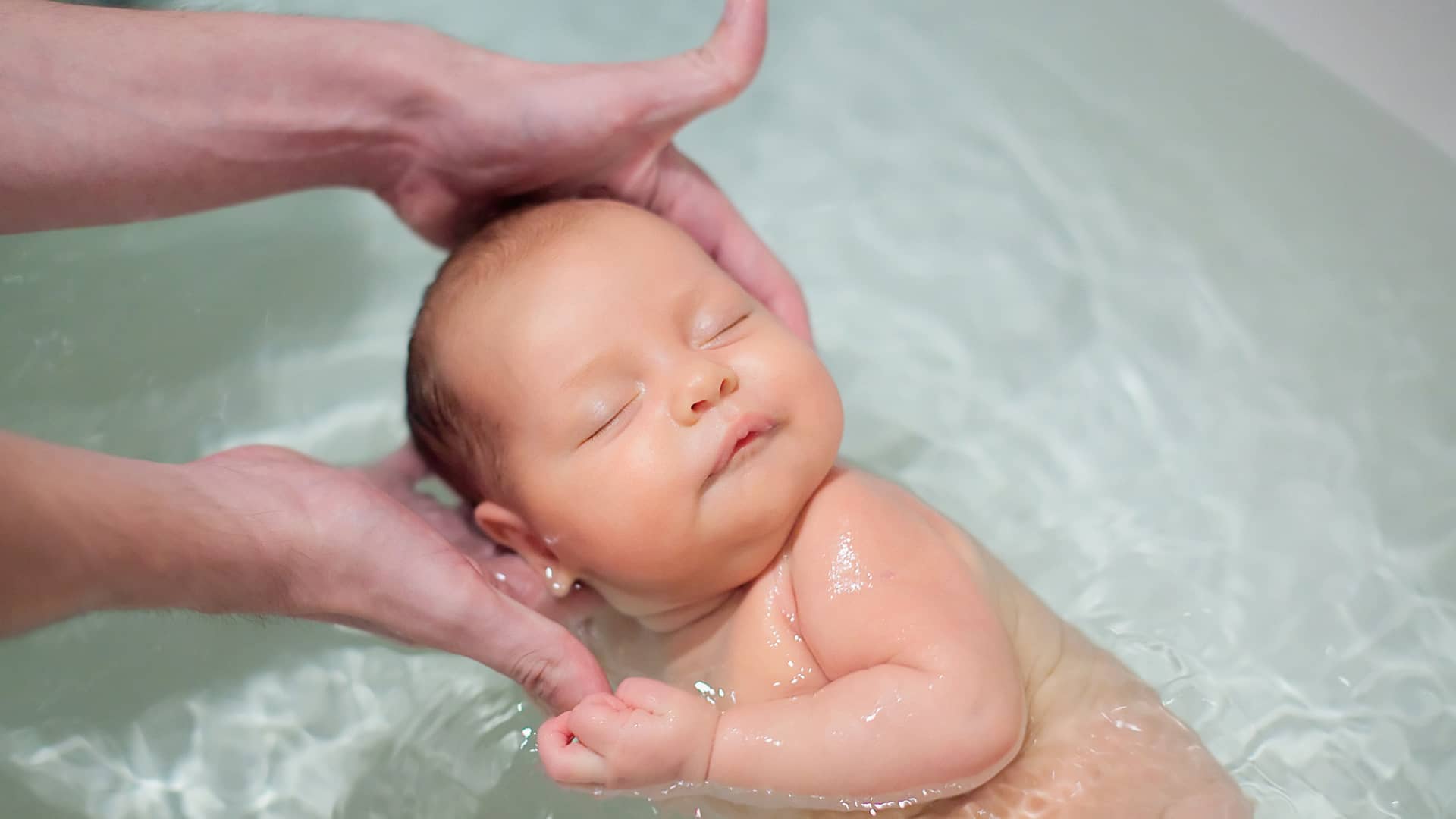 bebe muy tranquilo bañandose porque sus padres conocen la temperatura adecuada del baño del bebe