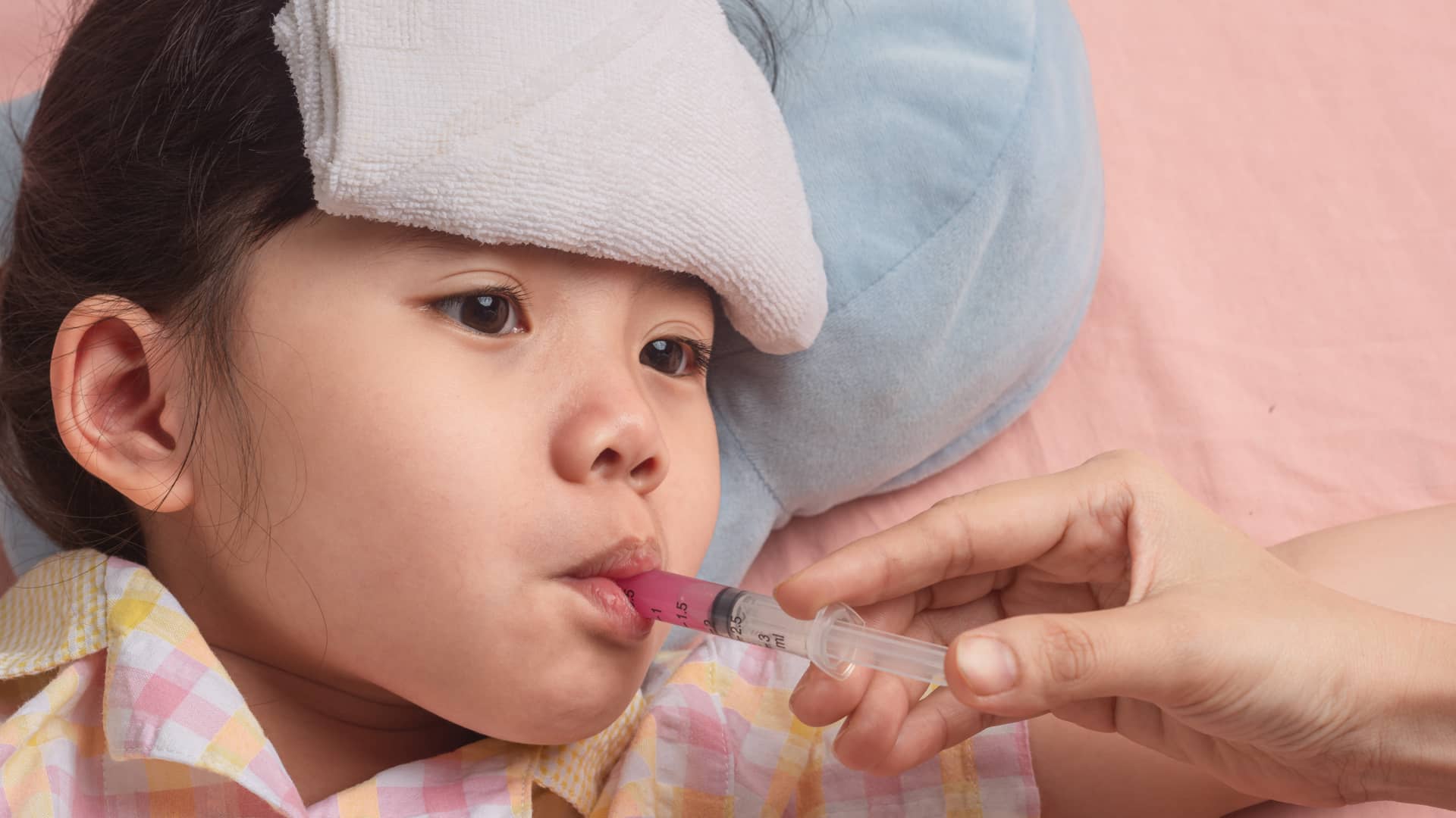 niña tomando apiretal con una jeringuilla que es un patacetamol especial para niños y bebes