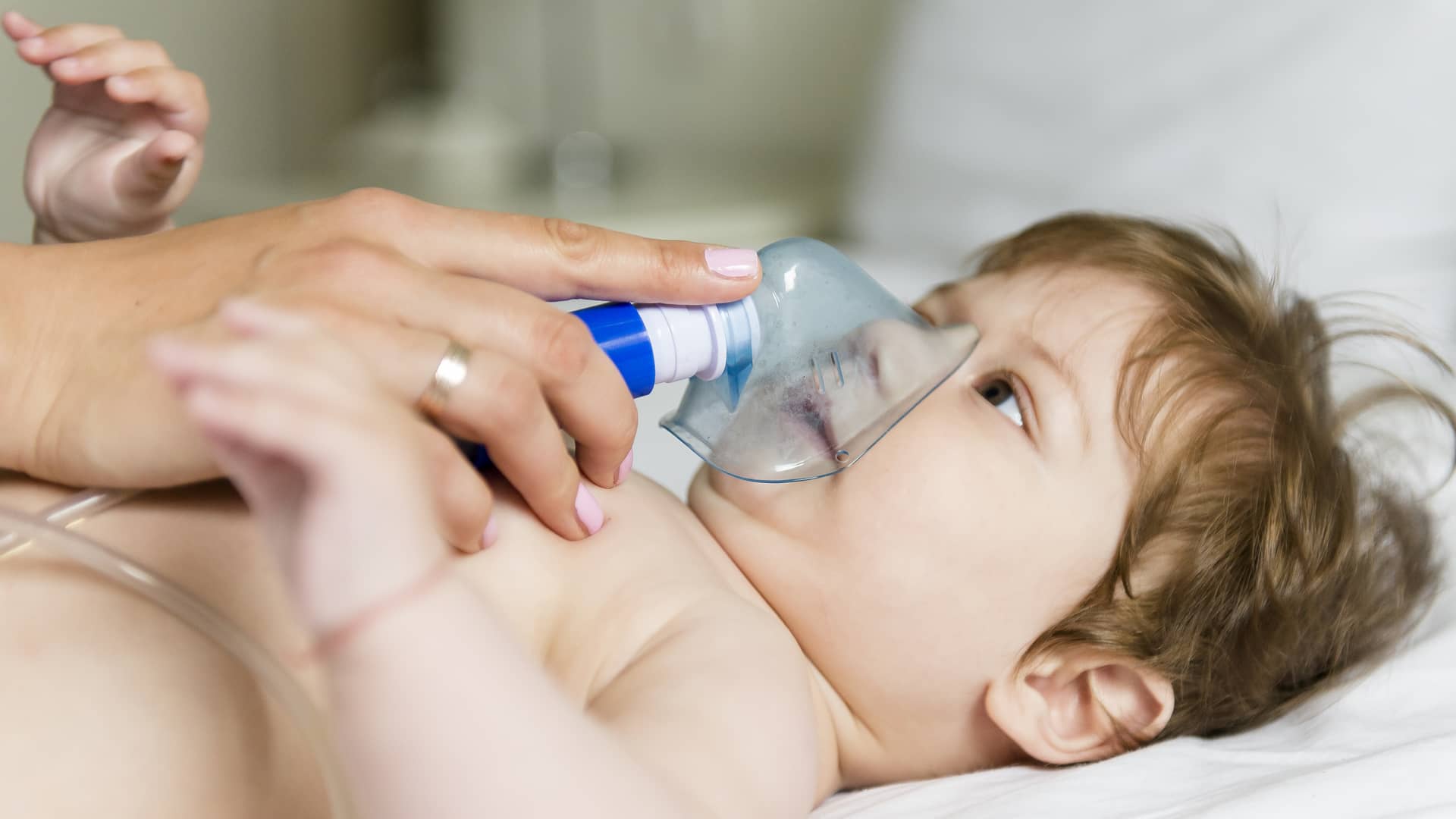 mama colocando una mascarilla de oxigeno a su bebe que sufre apnea mama colocando una mascarilla de oxigeno a su bebe que sufre apnea