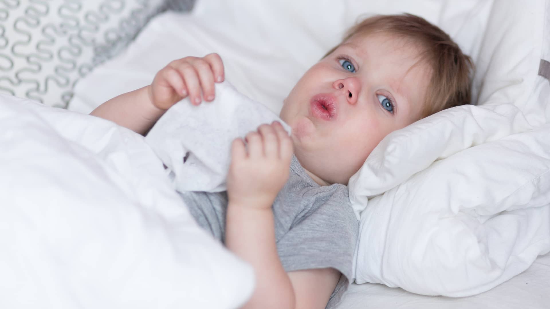 bebe tosiendo tumabdo en una cama porque tiene flemas