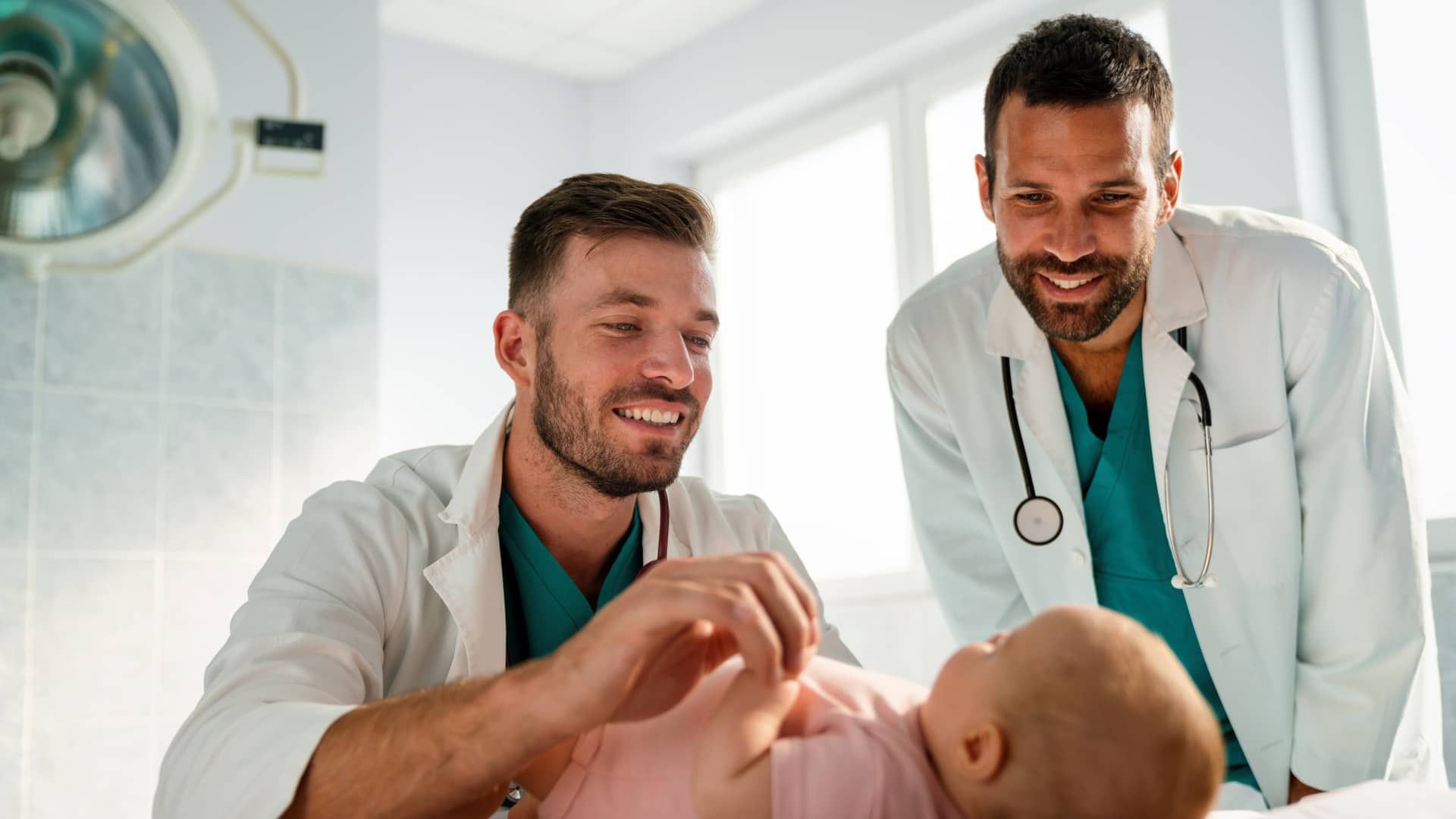 dos medicos atendiendo a un bebe en la consulta que tiene laringitis