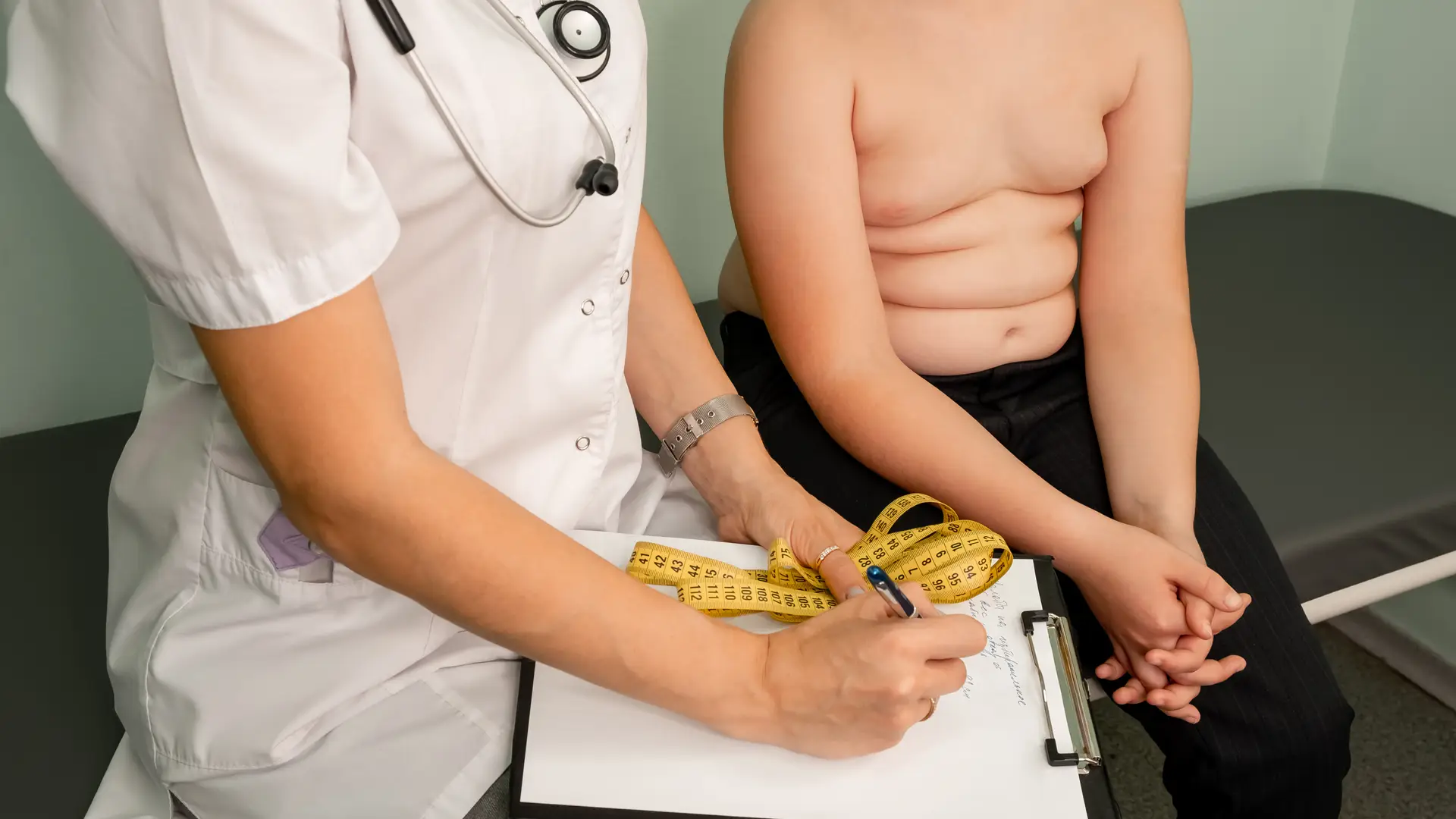 niño en la consulta del medico al que quieren controlar su obesidad infantil