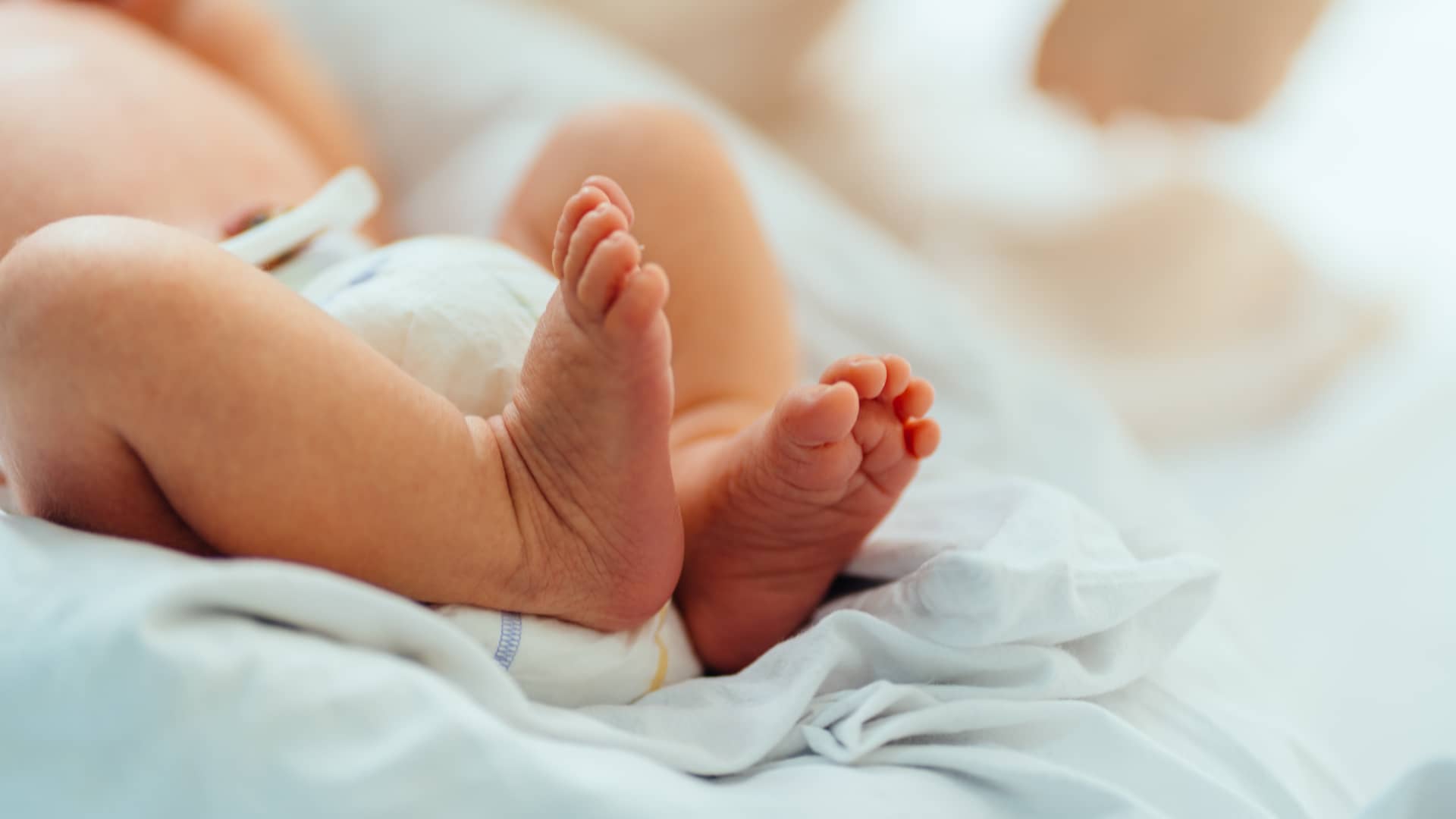 Cuerpo d eun bebé recien nacido solo vestido con un pañal que le mantiene limpio de meconio