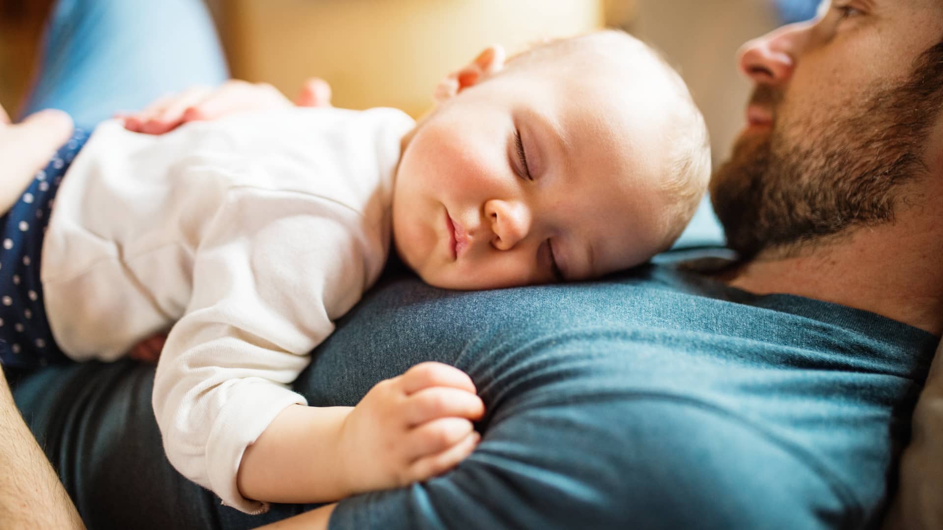 un bebe durmiendo la siesta encima de su paddre para cumplir con las horas de sueño diarias que debe descansar un bebe durmiendo la siesta encima de su paddre para cumplir con las horas de sueño diarias que debe descansar