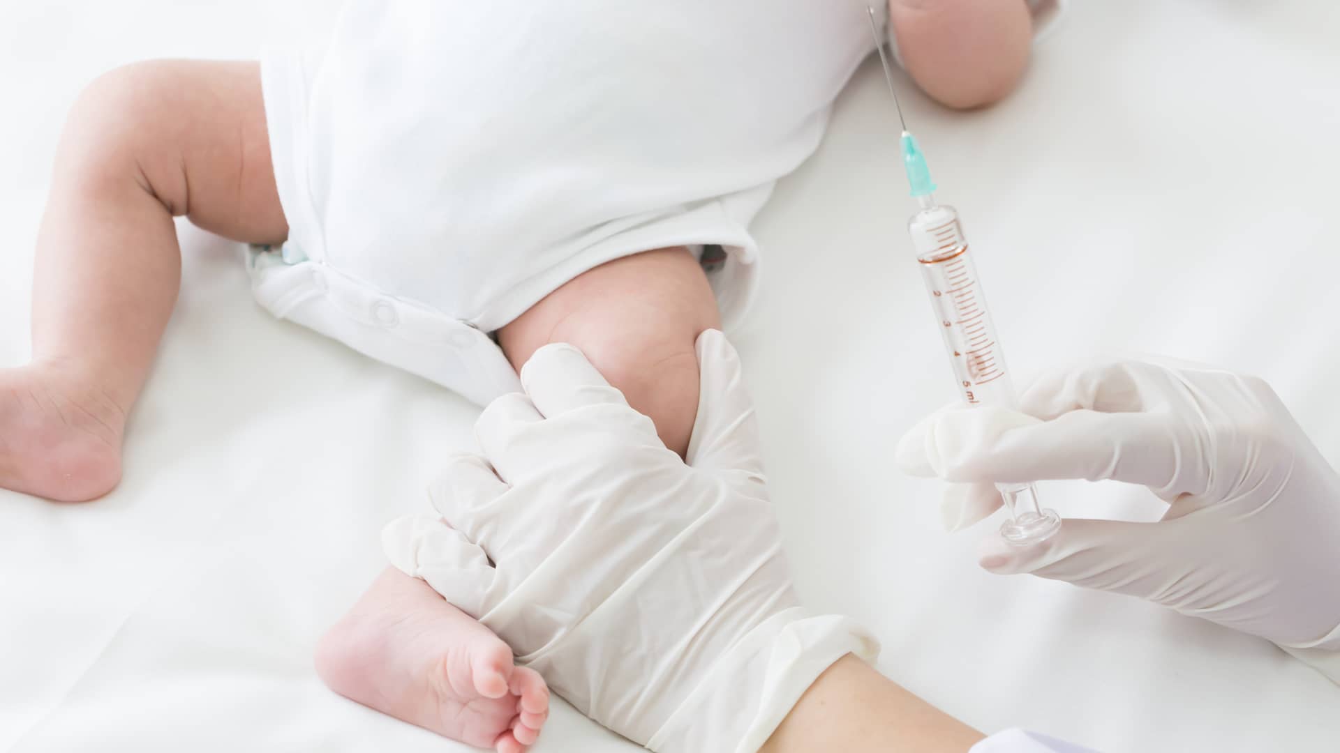 manos de una medico con guantes esteriles que va a poner las vacunas a los bebes de su centro de salud